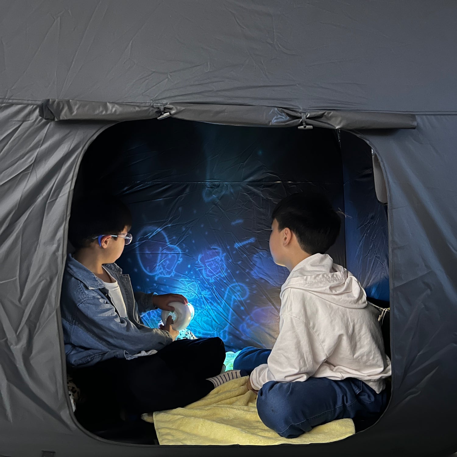 tow kids are playing light projector in lukidoki large sensory tent